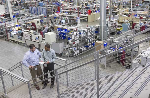 Woodward members having a discussion on the manufacturing floor 