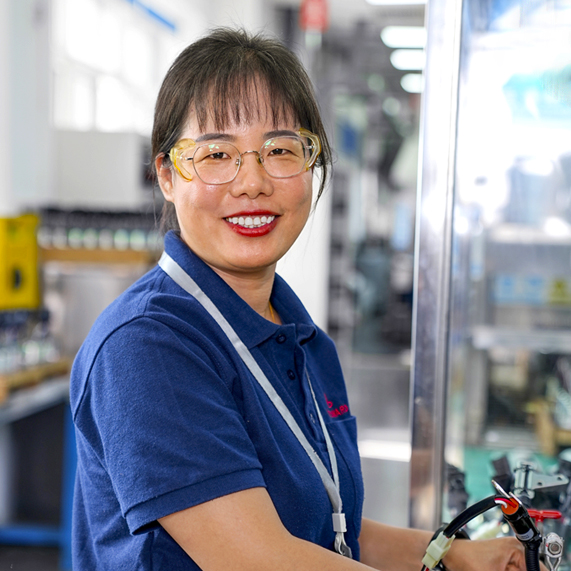 Woodward member smiling at work with safety goggles on