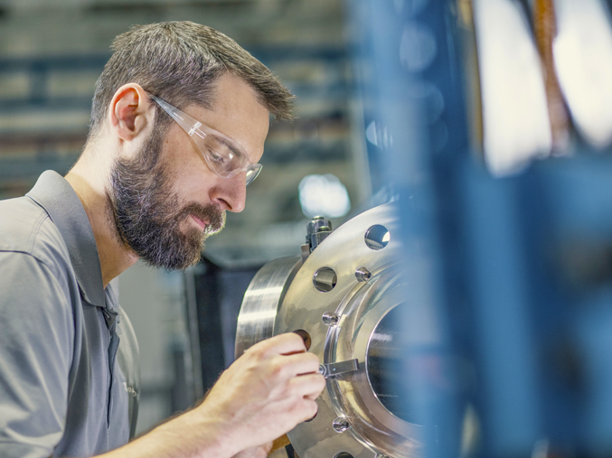 Man working on manufacturing a product wearing safety goggles